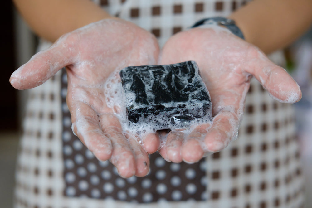 Activated charcoal soap Woman washing her hands with black handmade soap Runoku all natural soap