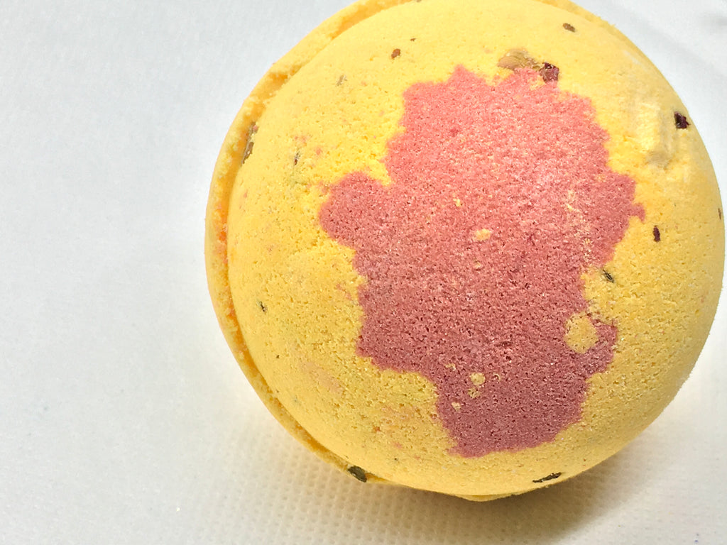 Runoku all natural round bath bomb made with all natural ingredients. Smells like honeysuckle, clean mild and floral. Round yellow bath ball with a red accent. 4.5 oz made with organic shea butter for softer skin results
